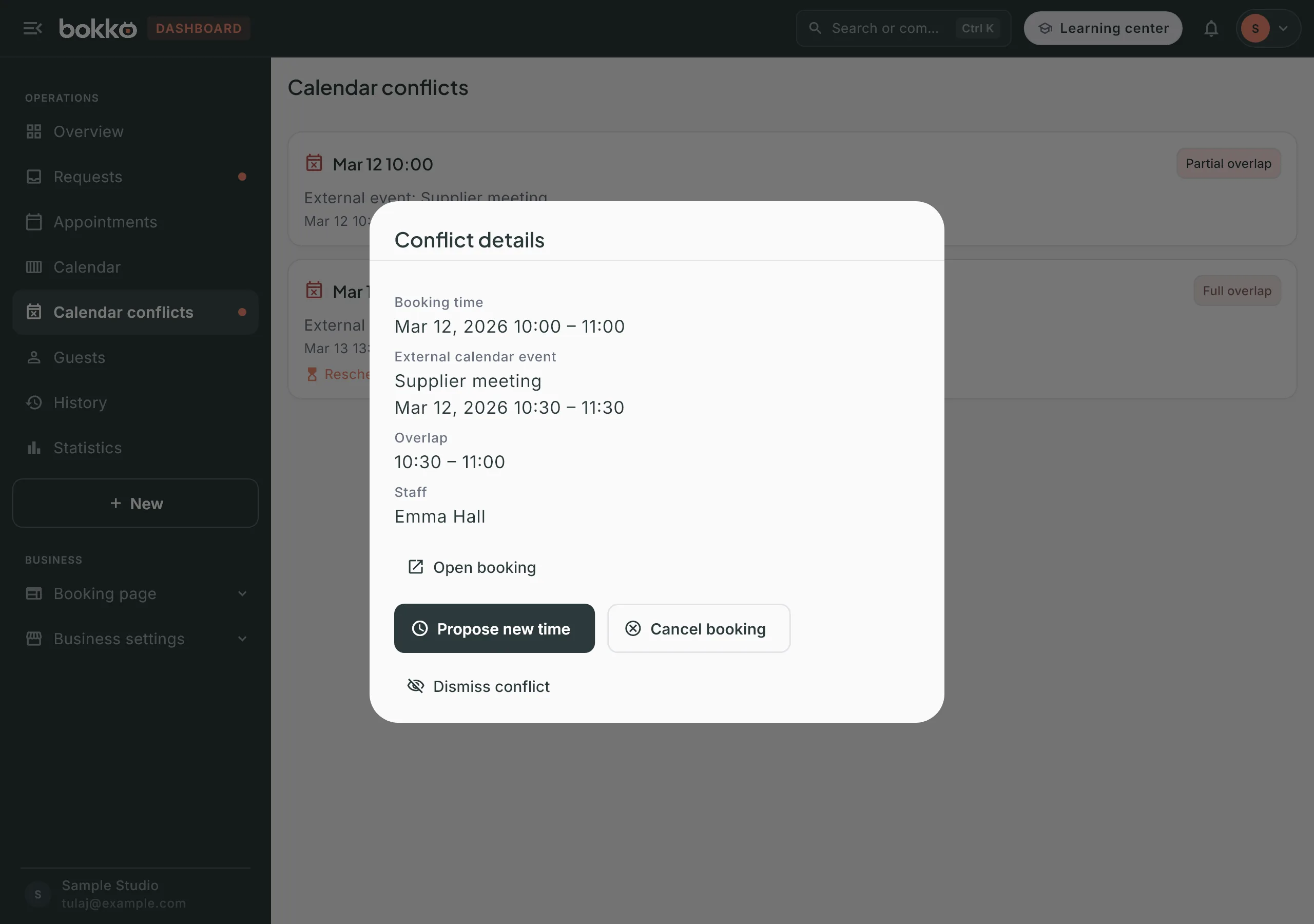 Conflict details: the booking and external event times, the overlap, Open booking, and the Propose new time, Cancel booking and Dismiss conflict buttons